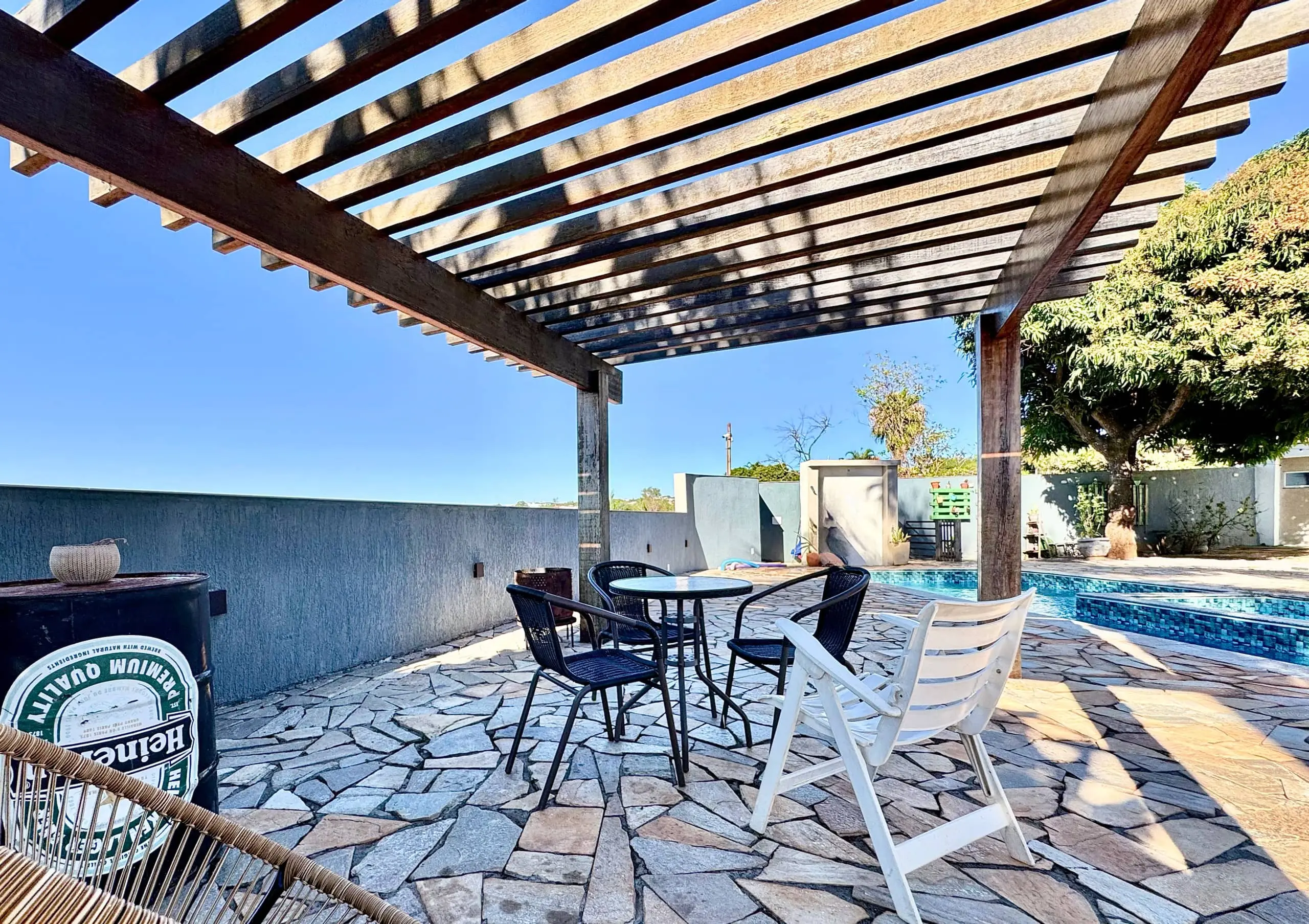 Área externa da Casa Redonda, com deck de pedra e vegetação tropical.